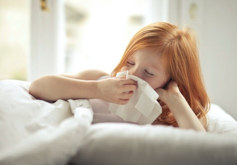 A Sick Girl Wiping Her Nose with Tissue